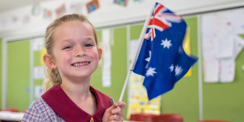 Canberra Outside School Hours Care - Young Australian girl waving the Australian flag.