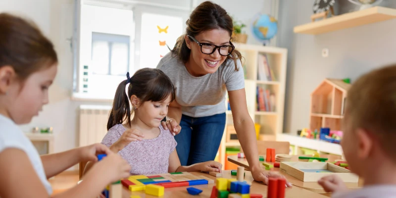 Canberra Preschools - Preschool teacher happily engaging with children.